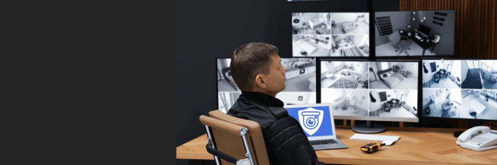 Sicherheitsmitarbeiter überwacht mehrere Bildschirme mit CCTV-Aufnahmen in einem Kontrollraum – Symbol für Videoüberwachung und Sicherheitssysteme